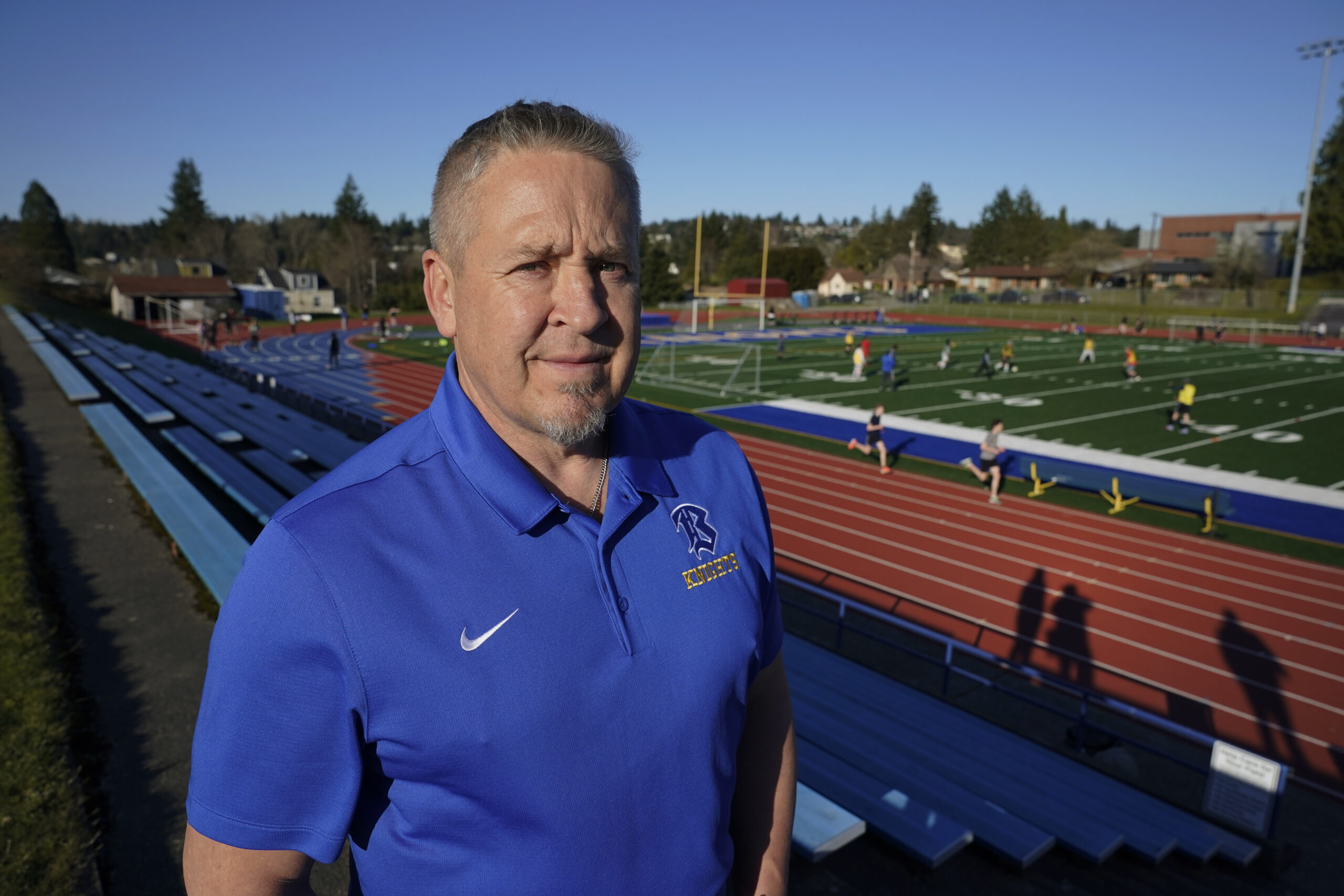 Joe Kennedy, a former assistant football coach at Bremerton High School in Bremerton, Washington, poses for a photo March 9, 2022, at the school’s football field. After losing his coaching job for refusing to stop kneeling in prayer with players and spectators on the field immediately after football games, Kennedy took his arguments before the U.S. Supreme Court on April 25, 2022, saying the Bremerton School District violated his First Amendment rights by refusing to let him continue praying at midfield after games. (AP Photo/Ted S. Warren)