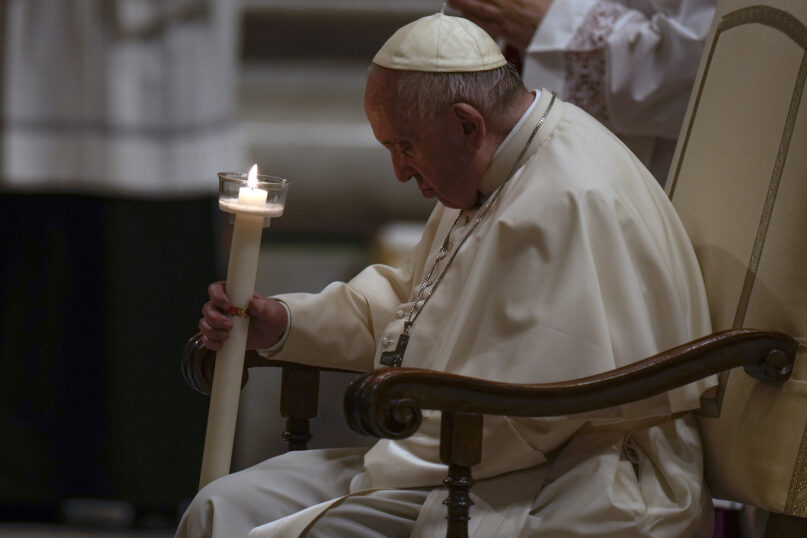 Pope Francis holds a Paschal candle as he presides over an Easter vigil ceremony at St. Peter's Basilica at the Vatican, Saturday, April 16, 2022. (AP Photo/Alessandra Tarantino)
