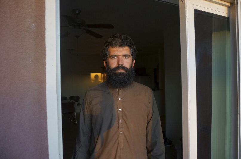 Wolayat Khan Samadzoi watches through the open balcony door of his apartment for the sliver of new moon to appear in the cloudless sky, where the sun had set beyond a desert mountain, in Las Cruces, N.M., Saturday, April 2, 2022. Samadzoi and thousands of other Afghans evacuated to the United States as the Taliban regained power last summer are celebrating their first Muslim holy month of Ramadan here – grateful to be safe, but agonizing over their families back home under the repressive Taliban regime. (AP Photo/Giovanna Dell'Orto)