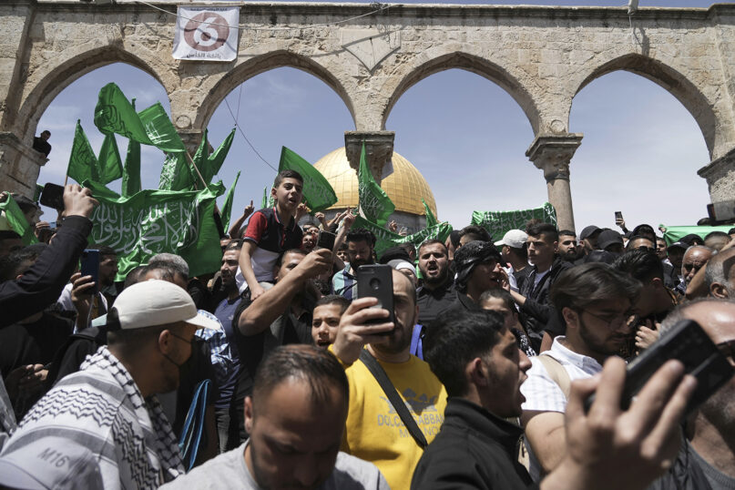 Palestinians chant slogans and wave Hamas flags after Friday prayers during the Muslim holy month of Ramadan, hours after Israeli police clashed with protesters at the Al-Aqsa Mosque compound in Jerusalem's Old City, Friday, April 22, 2022. (AP Photo/Mahmoud Illean)