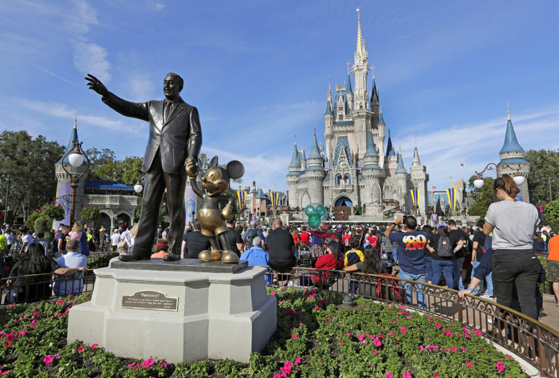 In this Jan. 9, 2019, file photo, guests watch a show near a statue of Walt Disney and Mickey Mouse in front of the Cinderella Castle at the Magic Kingdom at Walt Disney World in Lake Buena Vista, part of the Orlando area in Florida.  (AP Photo/John Raoux, File)