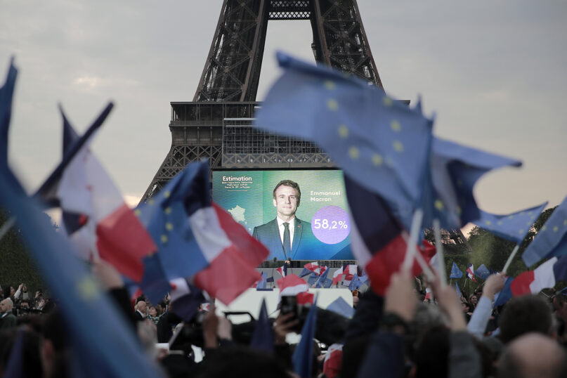 Supporters of French President Emmanuel Macron celebrate reports of his victory April 24, 2022, in Paris. (AP Photo/Lewis Joly)
