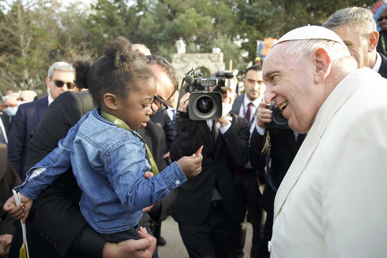 Pope Francis speaks to a young girl as he leaves the 'John XXIII Peace Lab' center for migrants in Hal Far, Malta, Sunday, April 3, 2022. Pope Francis prayed for the world to show more kindness and compassion to refugees as he paid tribute Sunday in Malta to the shipwrecked St. Paul and meets with migrants who, like the apostle, arrived on the Mediterranean island and were welcomed. (AP Photo/Rene Rossignaud)