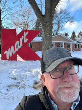 Pastor Paul Knight takes a selfie with the K-Mart sign that mysteriously showed up in front of his home in Grand Forks, North Dakota. Photo courtesy of Paul Knight
