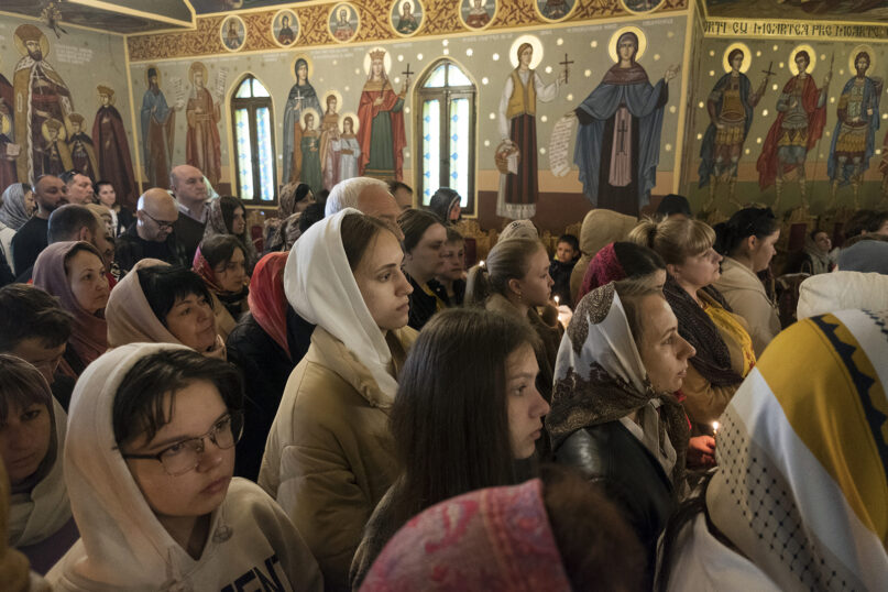 Approximately 300 refugees and members of the Ukrainian community in Bucharest attend Orthodox Easter services on April 24, 2022, at St. Petru Movila Orthodox Church in the Romanian capital. RNS photo by Alexandra Radu