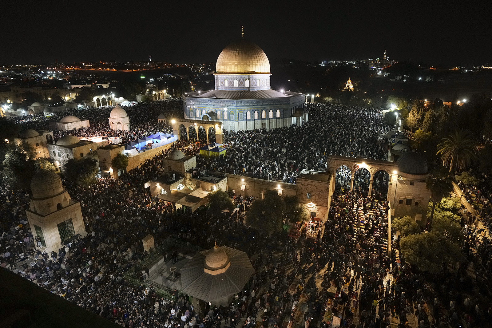 Adoradores muçulmanos palestinos rezam durante Laylat Al Qadr, também conhecida como a Noite do Poder, em frente à Mesquita Cúpula da Rocha, no complexo da Mesquita Al Aqsa na Cidade Velha de Jerusalém, quarta-feira, 27 de abril de 2022. Laylat Al Qadr está marcado no 27º dia do mês sagrado de jejum do Ramadã e é comemorado como a noite em que o Profeta Muhammad recebeu a primeira revelação do Alcorão. Os muçulmanos tradicionalmente passam a noite em oração e devoção. (Foto AP/Mahmoud Illean)