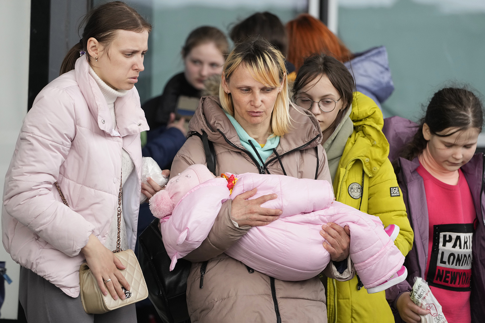 Refugee women with children walk to board transport at the central train station in Warsaw, Poland, Thursday, April 7, 2022. (AP Photo/Czarek Sokolowski)