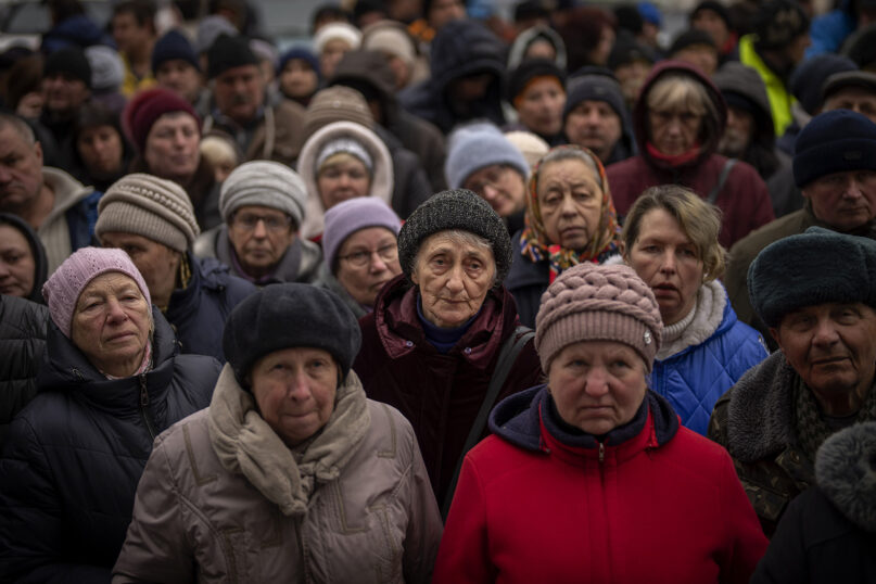 Ukrainians wait for a food distribution organized by the Red Cross in Bucha, on the outskirts of Kyiv, on April 18, 2022. (AP Photo/Emilio Morenatti)