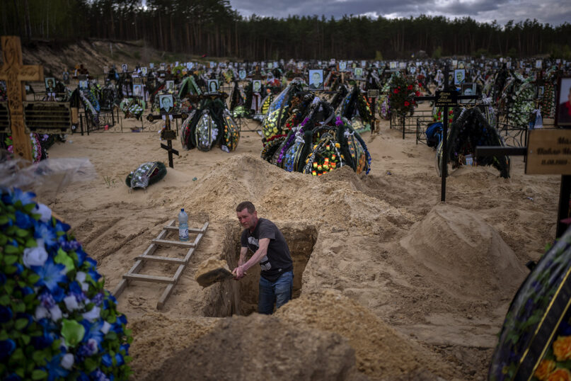 Gravedigger Alexander digs a grave at the cemetery of Irpin, on the outskirts of Kyiv, Ukraine, on Wednesday, April 27, 2022. (AP Photo/Emilio Morenatti)