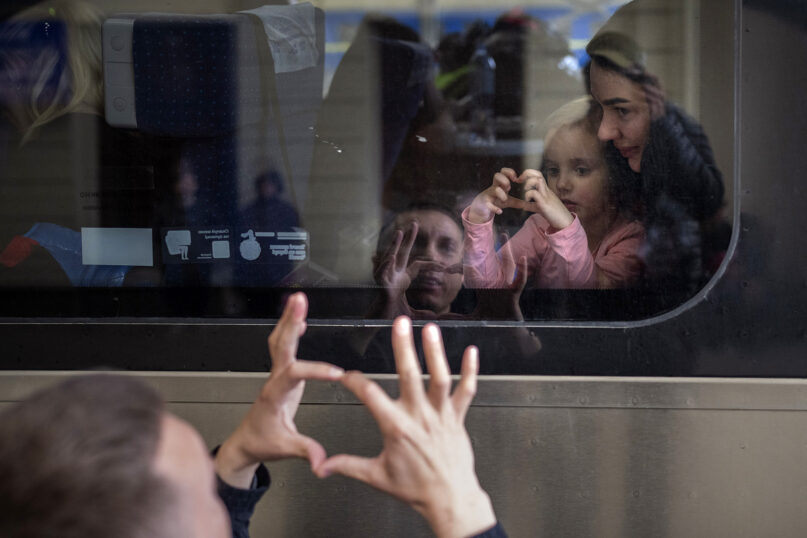 Ukrainian Nicolai, 41, says goodbye to his daughter Elina, 4, and his wife, Lolita, on a train bound for Poland fleeing from the war at the train station in Lviv, western Ukraine, April 15, 2022. (AP Photo/Emilio Morenatti)