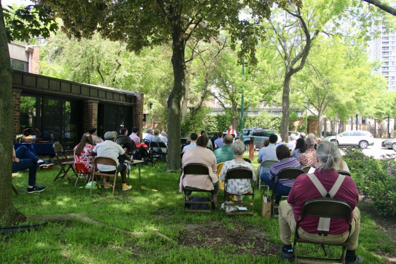 The congregation gathers outdoors on May 29, 2022, at Church of the Three Crosses in Chicago. RNS photo by Emily McFarlan Miller