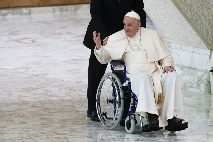 Pope Francis arrives in a wheelchair to attend an audience with nuns and religious superiors in the Paul VI Hall at the Vatican, May 5, 2022.  The pope is known to be suffering acute knee pain that has greatly curtailed his mobility in recent months. (AP Photo/Alessandra Tarantino, File)