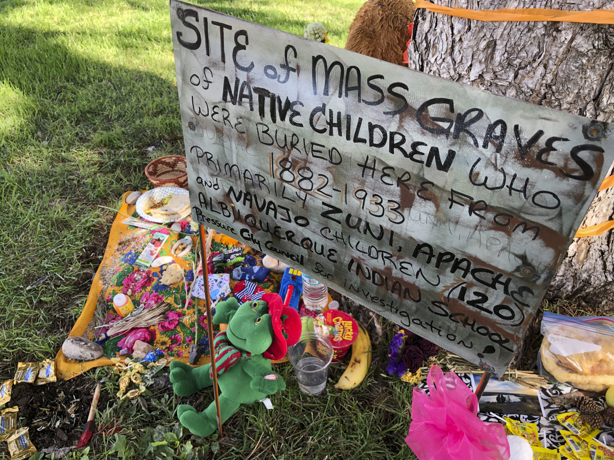 A makeshift memorial for the dozens of Indigenous children who died more than a century ago while attending a boarding school that was once located nearby is displayed under a tree at a public park in Albuquerque, New Mexico, on July 1, 2021. The U.S. Interior Department released a report May 11, 2022, about the federal government's past oversight of Native American boarding schools. (AP Photo/Susan Montoya Bryan, File)