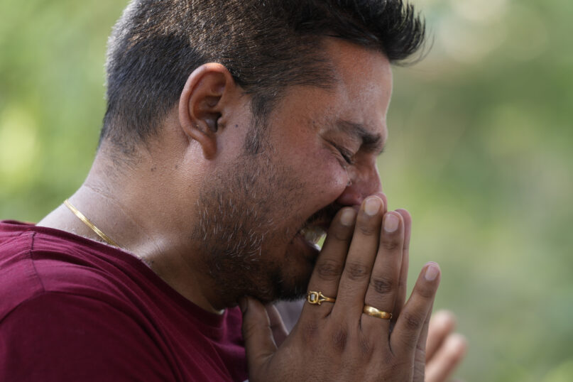 A man mourns during the cremation of a relative Rahul Bhat, who was a minority Kashmiri Hindu known as 
