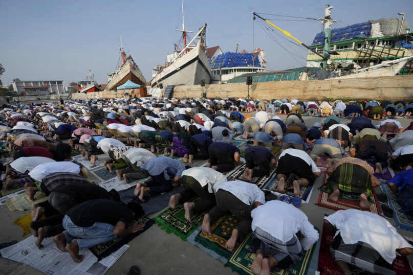 Muslim men offer Eid al-Fitr prayers to mark the end of the holy fasting month of Ramadan at Sunda Kelapa port in Jakarta, Indonesia, Monday, May 2, 2022. (AP Photo/Tatan Syuflana)