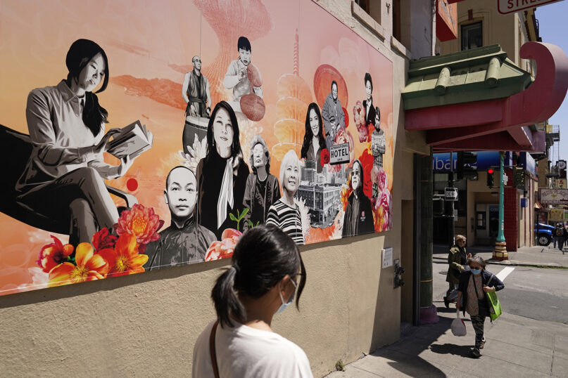 Two women walk along Jackson Street in Chinatown past the new 