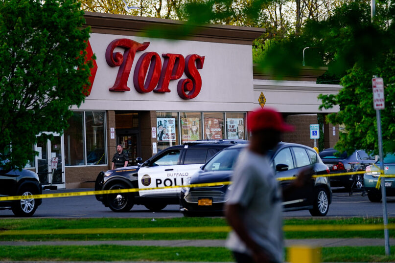A person walks past the scene of a shooting at a supermarket, in Buffalo, N.Y., Sunday, May 15, 2022. (AP Photo/Matt Rourke)