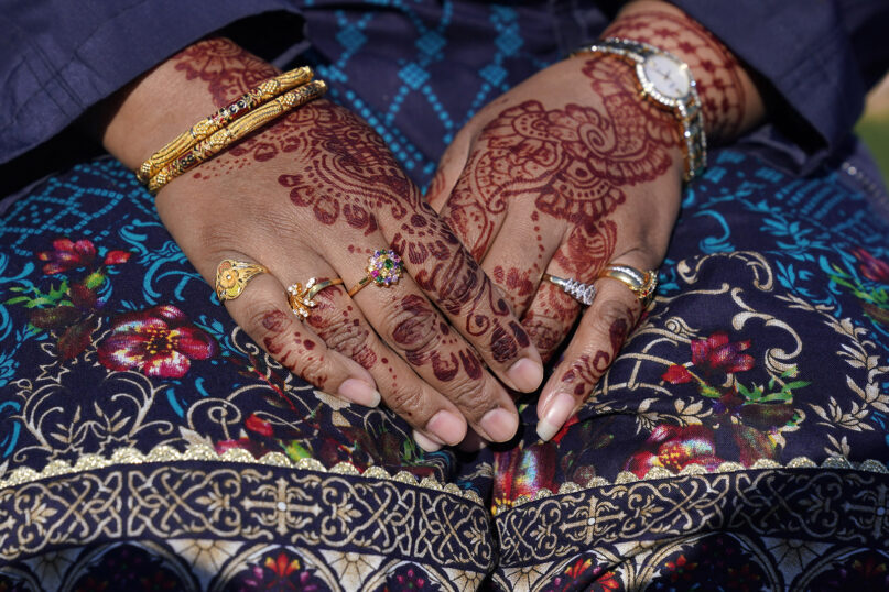 Tasneem Salam’s hands are decorated with henna as she attends an Eid al-Fitr celebration in Overpeck County Park in Ridgefield Park, New Jersey, May 13, 2021. This year, in a rare convergence, Judaism’s Passover, Christianity’s Easter and Islam’s holy month of Ramadan overlapped in April with holy days for Buddhists, Baha’is, Sikhs, Jains and Hindus, offering different faith groups a chance to share meals and rituals in a range of interfaith events. (AP Photo/Seth Wenig, File)