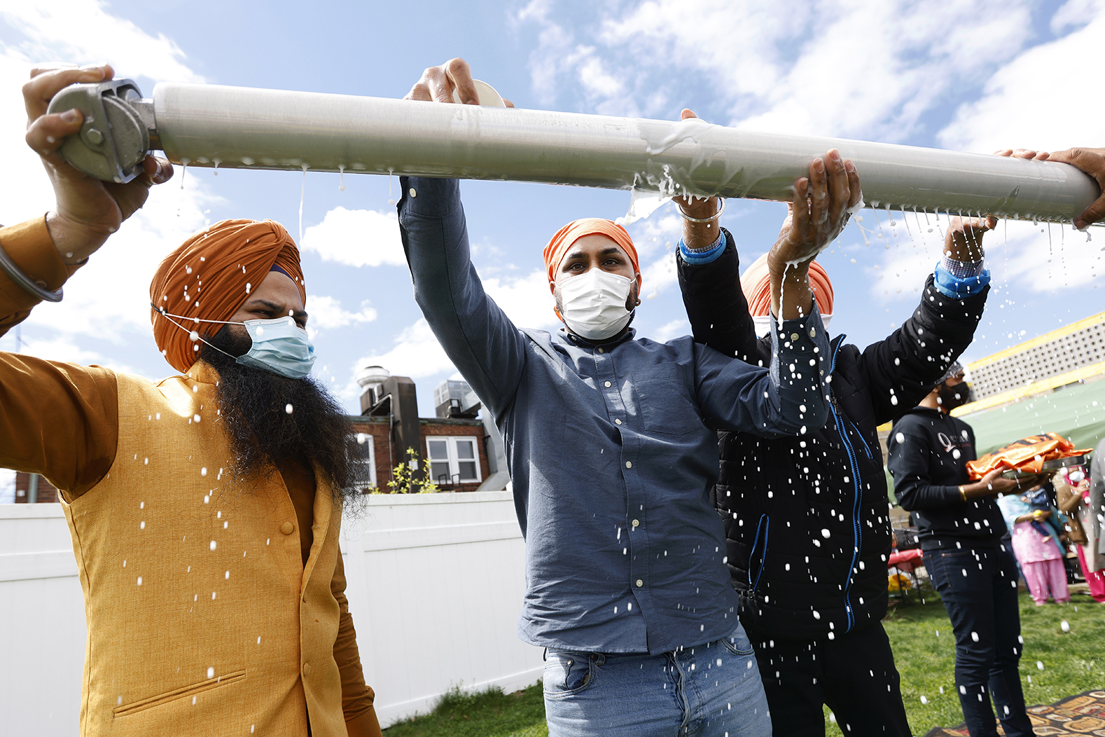 FILE - Jasbir Singh, left, and Vijay Singh wash a flagpole with milk as part of a ceremonial changing of the Sikh flag during Vaisakhi celebrations at Guru Nanak Darbar of Long Island, Tuesday, April 13, 2021 in Hicksville, N.Y. In a convergence that happens only rarely, Judaism’s Passover, Christianity’s Easter and Islam’s holy month of Ramadan overlapped in April with holy days for Buddhists, Baha’is, Sikhs, Jains and Hindus, offering different faith groups a chance to share meals and rituals in a range of interfaith events. (AP Photo/Jason DeCrow, File)
