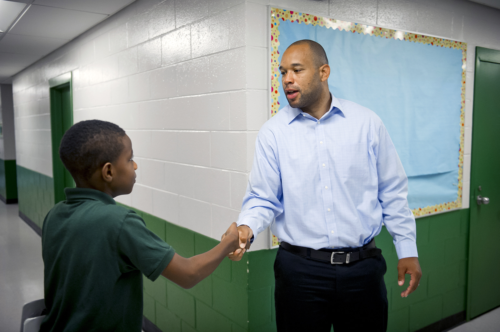 Marcus Washington greets a student in the halls at Washington Jesuit Academy in 2018 in Washington, D.C. Photo by Rod Lamkey Jr./WJA