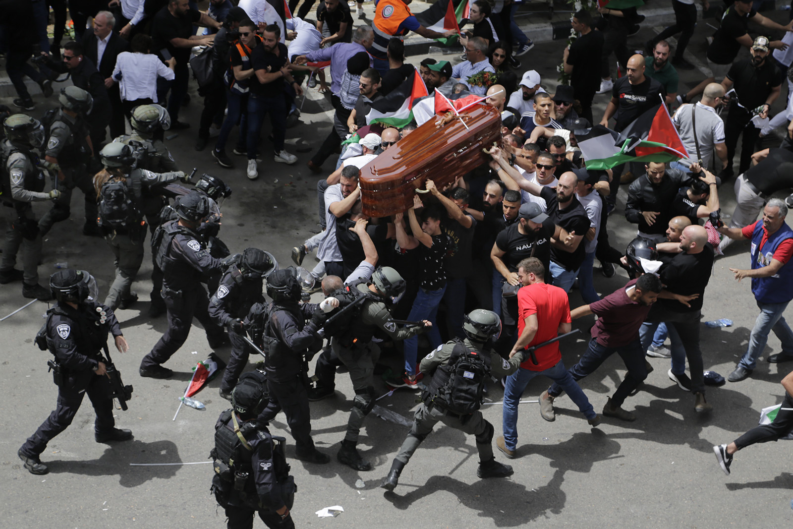 Israeli police confront mourners as they carry the casket of slain Al Jazeera veteran journalist Shireen Abu Akleh during her funeral in east Jerusalem, Friday, May 13, 2022. Abu Akleh, a Palestinian-American reporter who covered the Mideast conflict for more than 25 years, was shot dead Wednesday during an Israeli military raid in the West Bank town of Jenin. (AP Photo/Maya Levin)