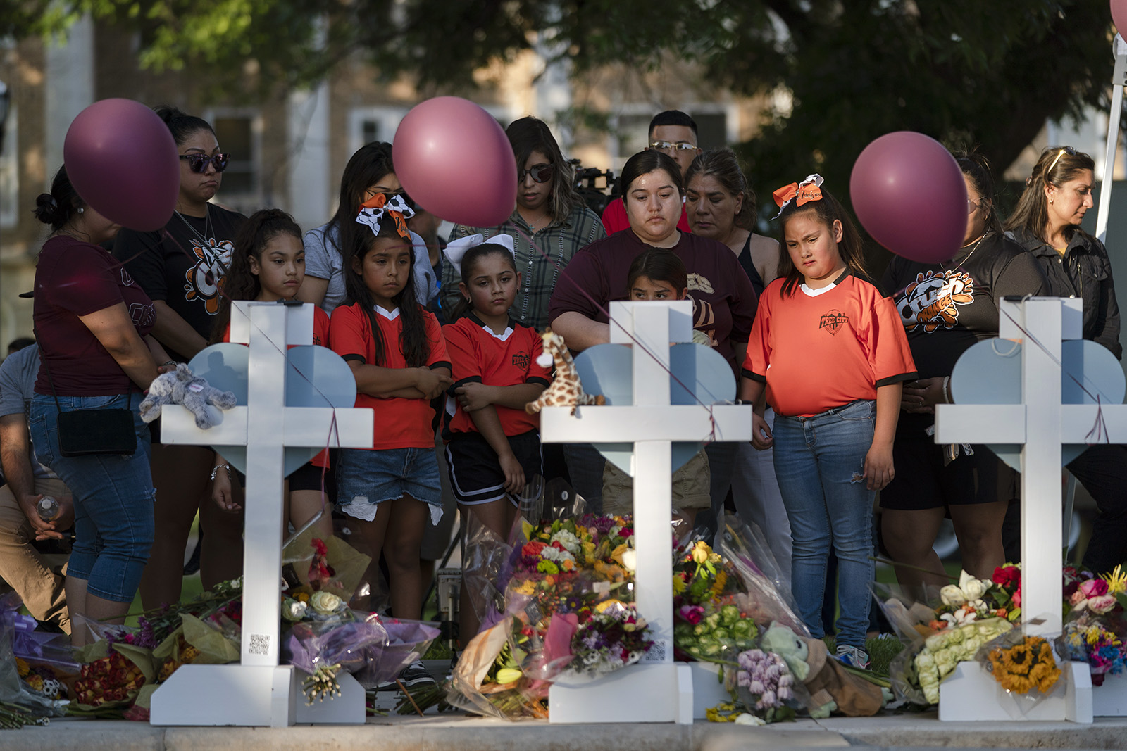 People gather at a memorial site to pay their respects for the victims killed in this week's elementary school shooting in Uvalde, Texas, Thursday, May 26, 2022. (AP Photo/Jae C. Hong)