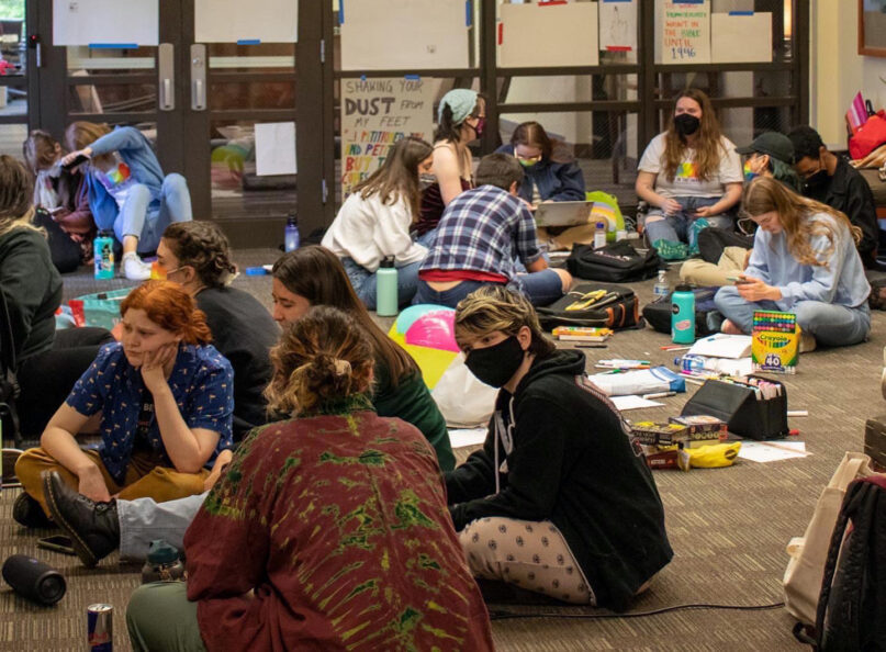 People participate in the third day of a sit-in at Seattle Pacific University, May 26, 2022, after the board of trustees decided to retain a policy that prohibits the hiring of LGBTQ people. Photo via Twitter/@SPUisGay