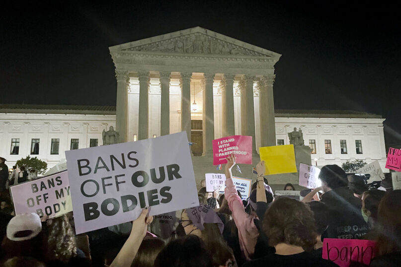 A crowd of people gather outside the U.S. Supreme Court, Monday night, May 2, 2022 in Washington. A draft opinion circulated among Supreme Court justices suggests that earlier this year a majority of them had thrown support behind overturning the 1973 case Roe v. Wade that legalized abortion nationwide, according to a report published Monday night in Politico. (AP Photo/Anna Johnson)