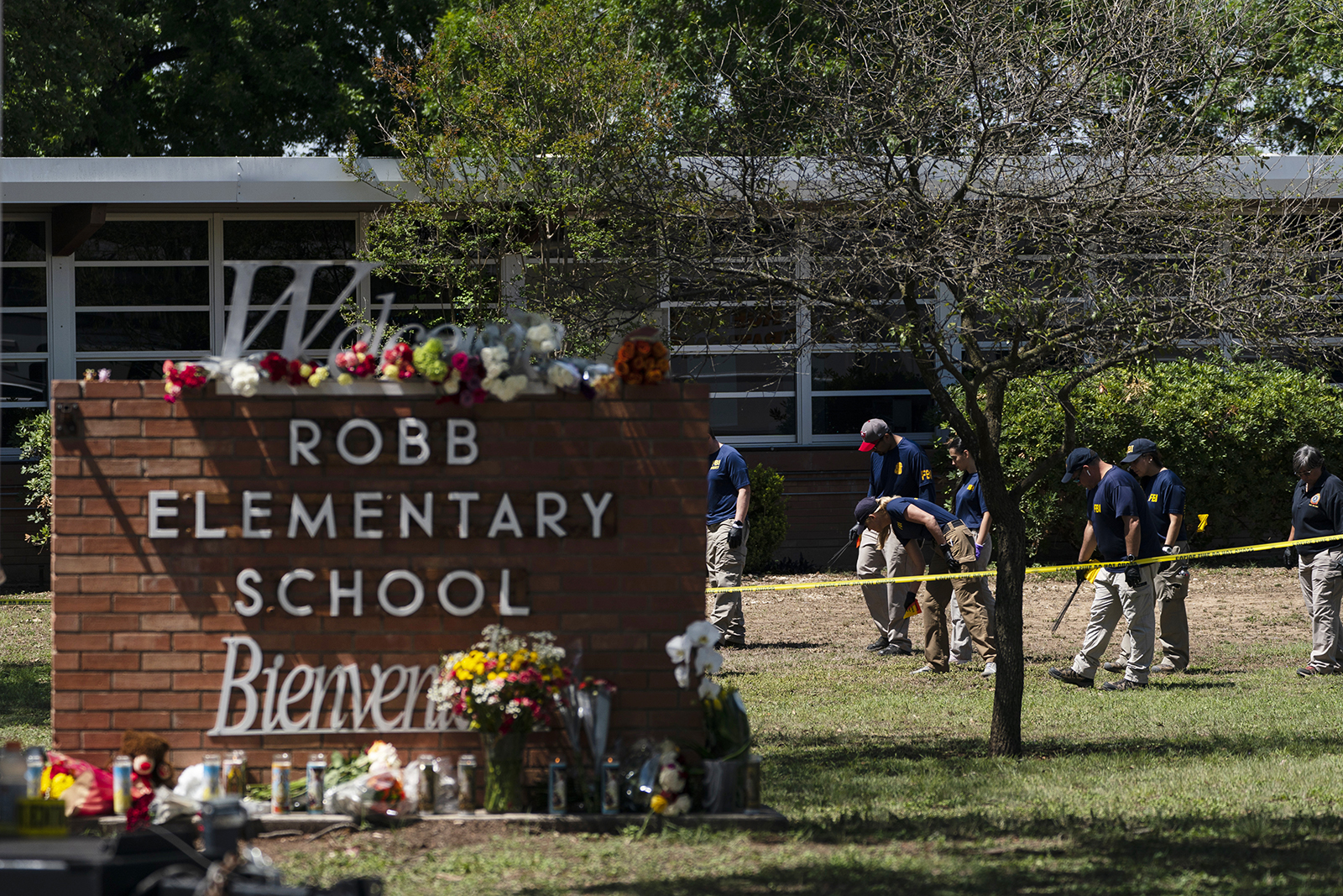 Investigators search for evidence outside Robb Elementary School in Uvalde, Texas, Wednesday, May 25, 2022. (AP Photo/Jae C. Hong)