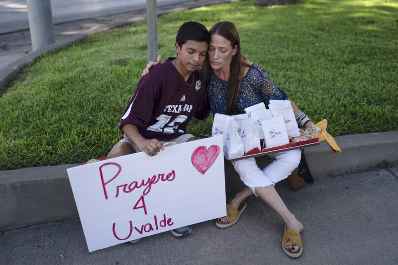 Diego Esquivel, left, and Linda Klaasson comfort each other May 25, 2022, as they gather to honor the victims killed in the shooting at Robb Elementary School in Uvalde, Texas. (AP Photo/Jae C. Hong)