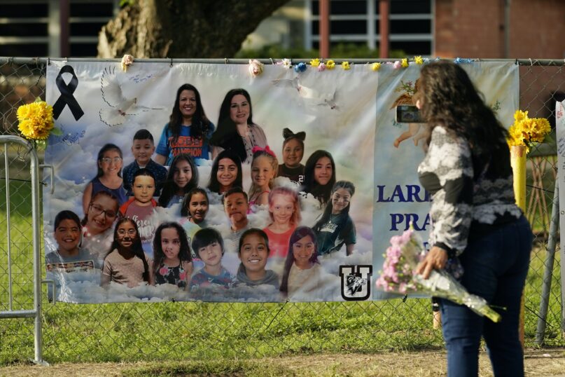 A visitor pays respects at a memorial created outside Robb Elementary School to honor the victims killed in the school shooting in Uvalde, Texas. (AP Photo/Eric Gay)