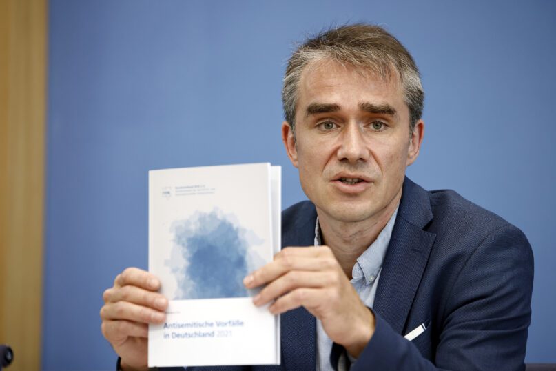 Benjamin Steinitz, executive director of the 'Bundesverband RIAS', shows the annual report at a press conference to present the annual report 'Anti-Semitic Incidents in Germany 2021' during a press conference in Berlin, Germany, Tuesday June 28, 2022. The RIAS group tracking antisemitism in Germany says it documented more than 2,700 incidents in the country last year including 63 attacks and six cases of extreme violence. (Carsten Koall/dpa via AP)