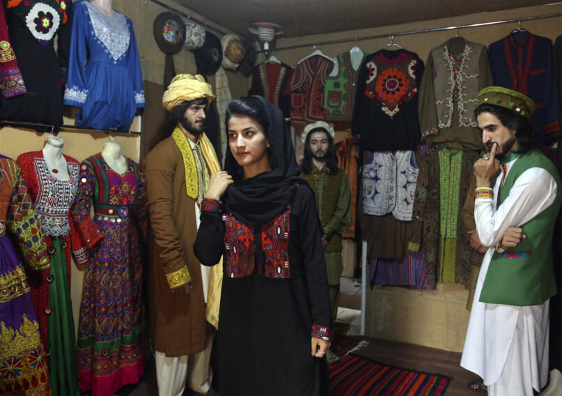 FILE - Ajmal Haqiqi, right, watches as Mahal Wak, center, practices modeling, in Kabul, Afghanistan, Aug. 3, 2017. The Taliban have detained a famous Afghan fashion model along with three colleagues, including Haqiqi, accusing them of disrespecting Islam and the Holy Quran. Haqiqi — known among Afghans for his fashion shows, You Tube clips, and modeling events — appeared handcuffed in videos posted to Twitter on Tuesday, June 7, 2022, by the Taliban’s General Directorate of Intelligence, DCI. (AP Photo/Rahmat Gul, File)