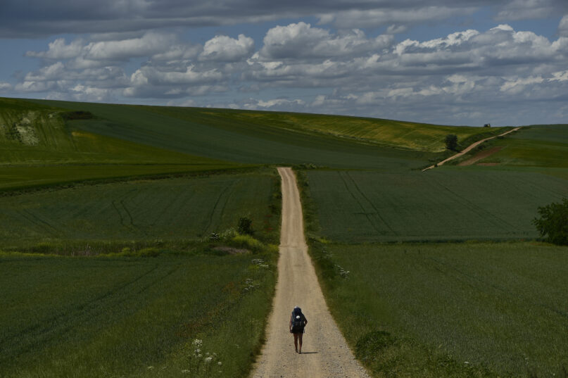 A pilgrim walks during a stage of 