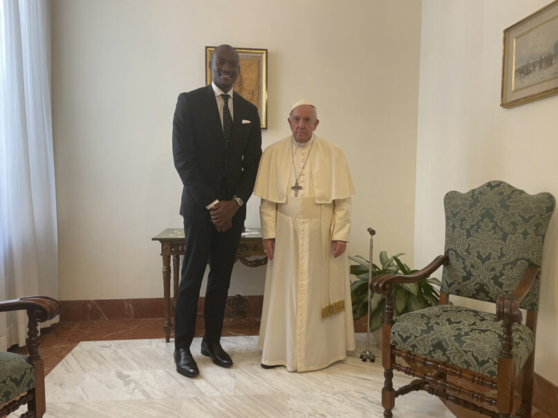 Pope Francis poses with Congolese-born NBA player with the Phoenix Suns Bismack Biyombo as they meet at The Vatican Tuesday, June 21, 2022, to talk about Biyombo's foundation benefiting children in Congo. (Hernan Reyes Alcade via AP)