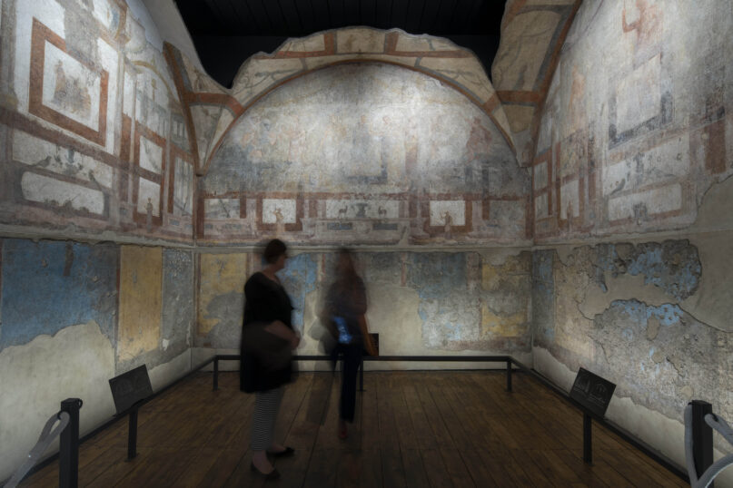 Journalists look at the frescoes coming from the sacellum, a small votive chapel, of a two-story home, or 