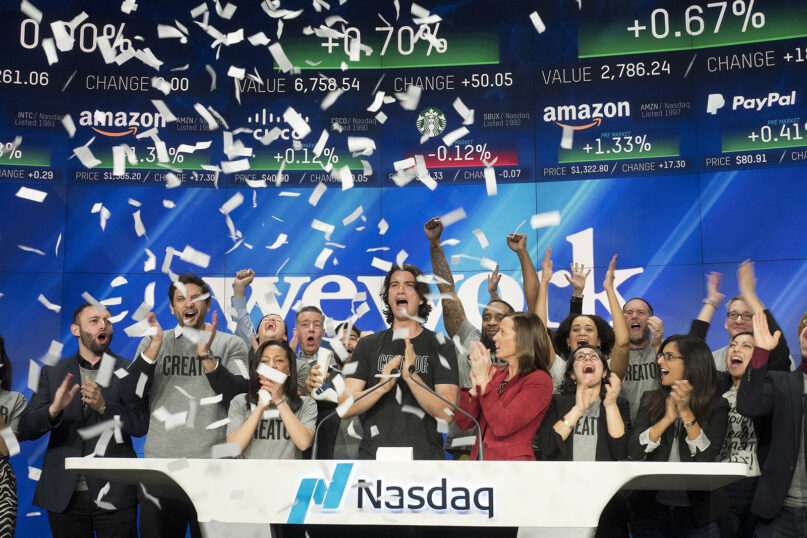 In this Jan. 16, 2018, file photo, Adam Neumann, center, co-founder and CEO of WeWork, attends the opening bell ceremony at Nasdaq in New York. (AP Photo/Mark Lennihan)