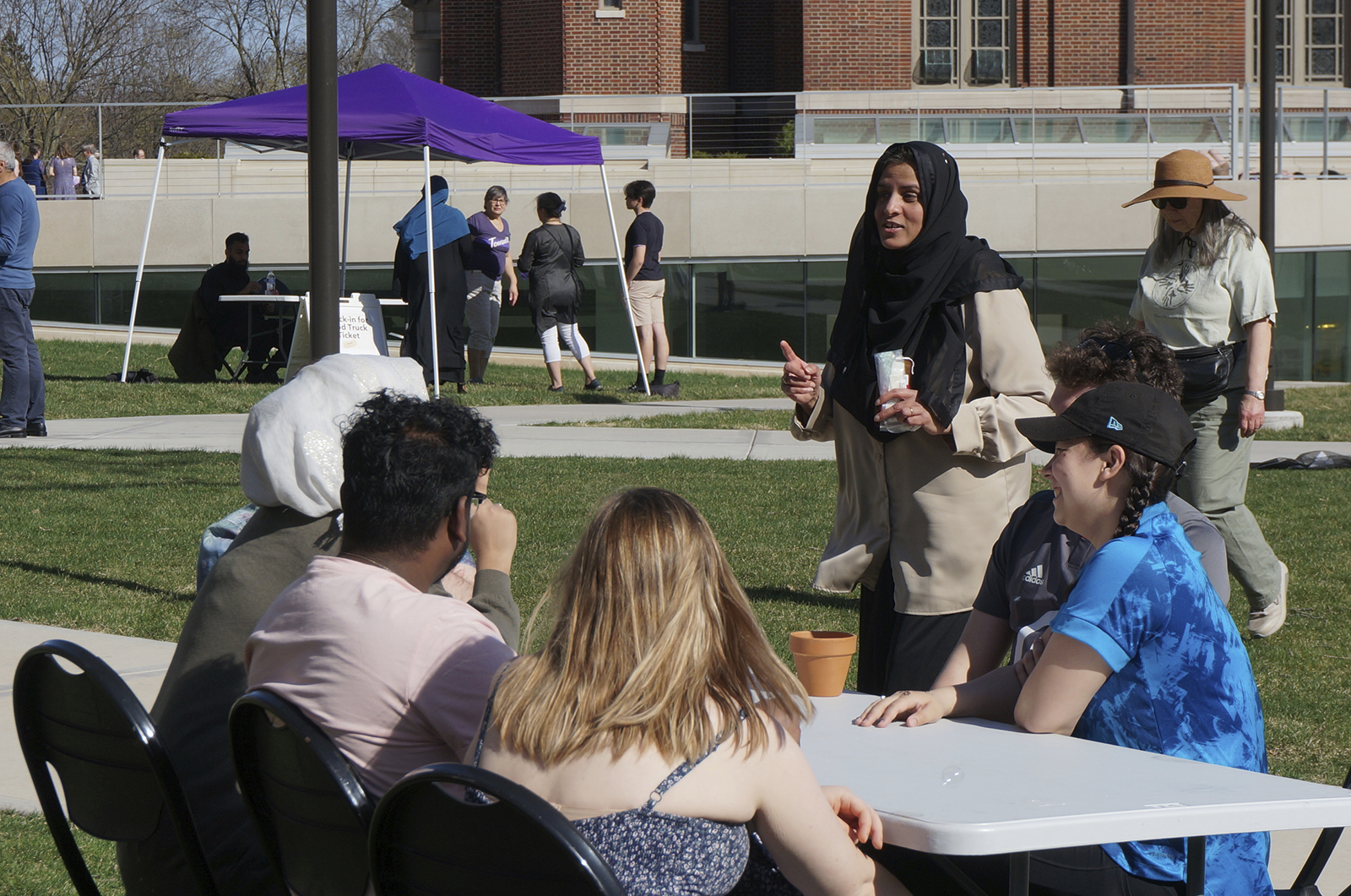 Sadaf Shier, standing, the Muslim chaplain at the University of St. Thomas, talks with students attending the school's celebration for the end of the Muslim holy month of Ramadan in St. Paul, Minn., on Saturday, May 7, 2022. She helped organize the event, which included several stress-reducing activities, as part of a broadening of the mission of campus ministry to address holistic student wellbeing. (AP Photo/Giovanna Dell'Orto)