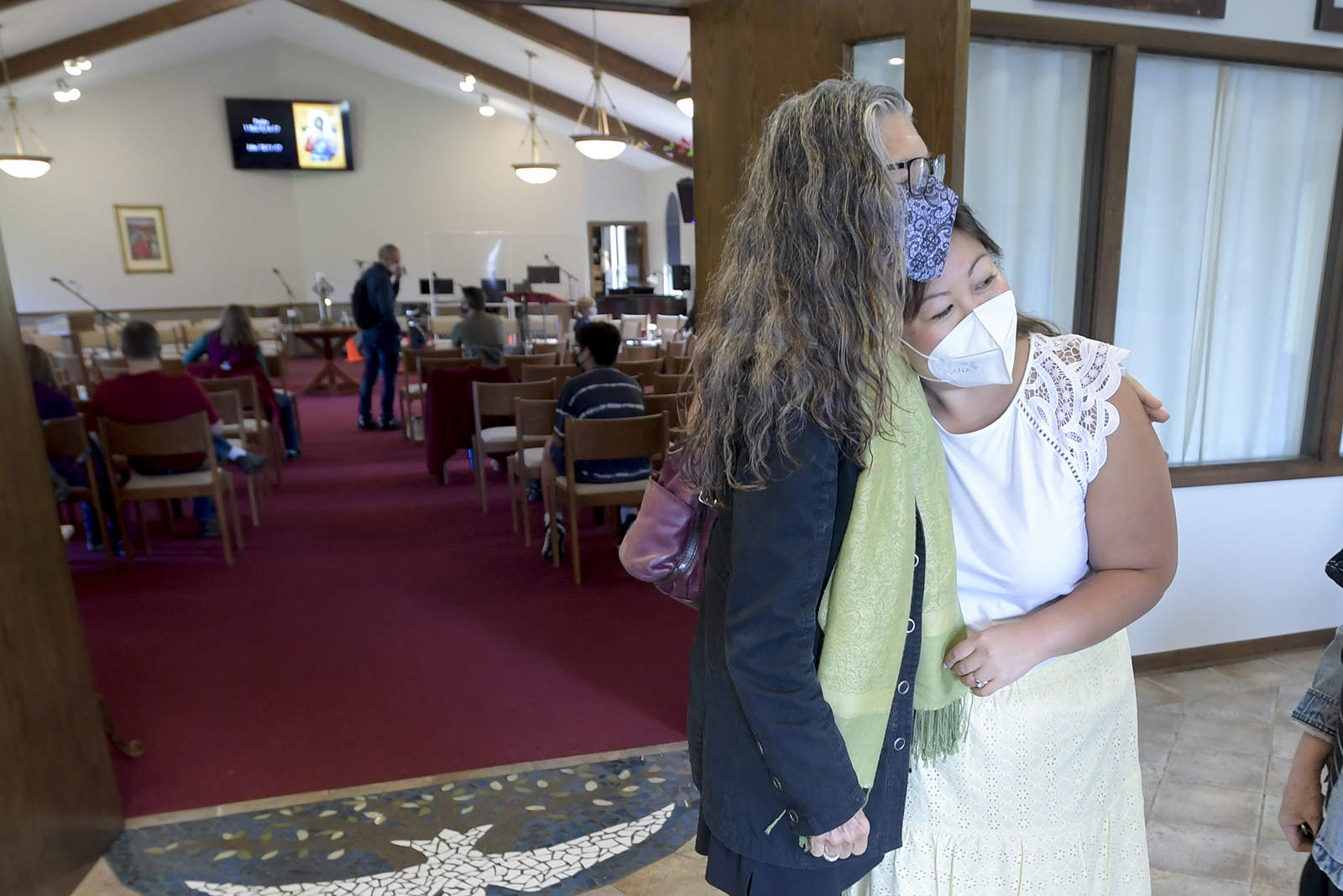 Parishioner Pam Sutherland, left, gives Pastor Juliet Liu a hug prior to services at Life on the Vine church in Long Grove, Ill., on Sunday, May 22, 2022. (AP Photo/Mark Black)