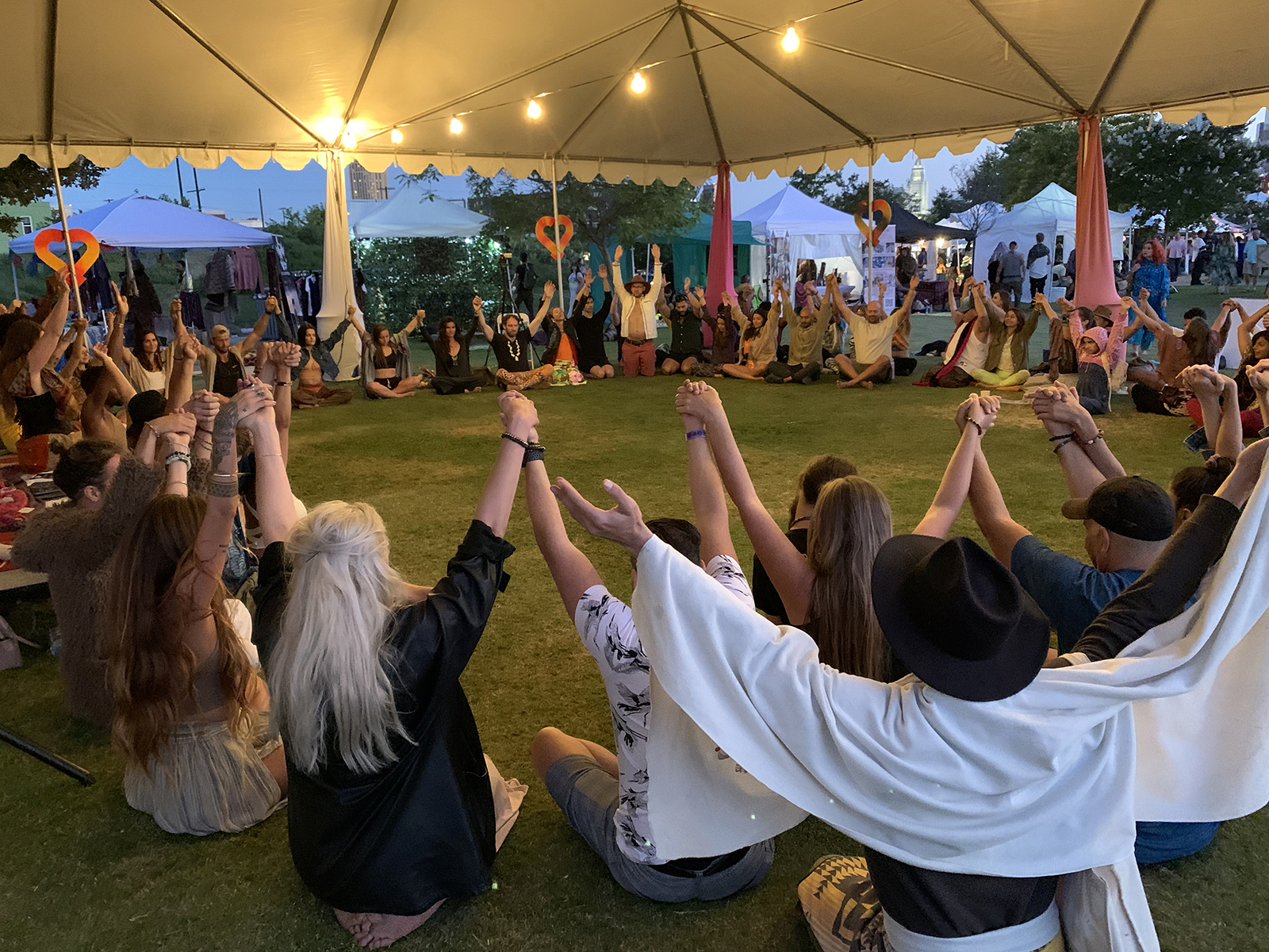 Attendees hold hands for a closing prayer after a session of guided ecstatic dance during DisclosureFest, Saturday, June 18, 2022, at the Los Angeles State Historic Park. Photo by Sam Kestenbaum