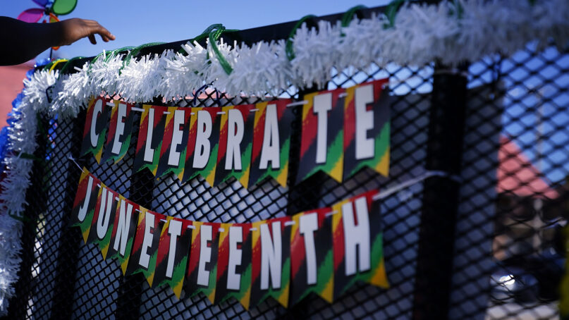 A Celebrate Juneteenth sign during a Juneteenth parade on Saturday, June 18, 2022, in East Point, Georgia. (AP Photo/Brynn Anderson)