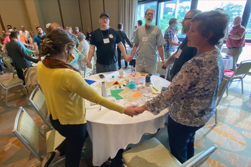 Mennonite Church USA delegates hold hands and sing after “A Resolution for Repentance and Transformation” was approved at the special session of the Delegate Assembly on May 29, 2022, in Kansas City, Missouri. Photo courtesy of MC USA