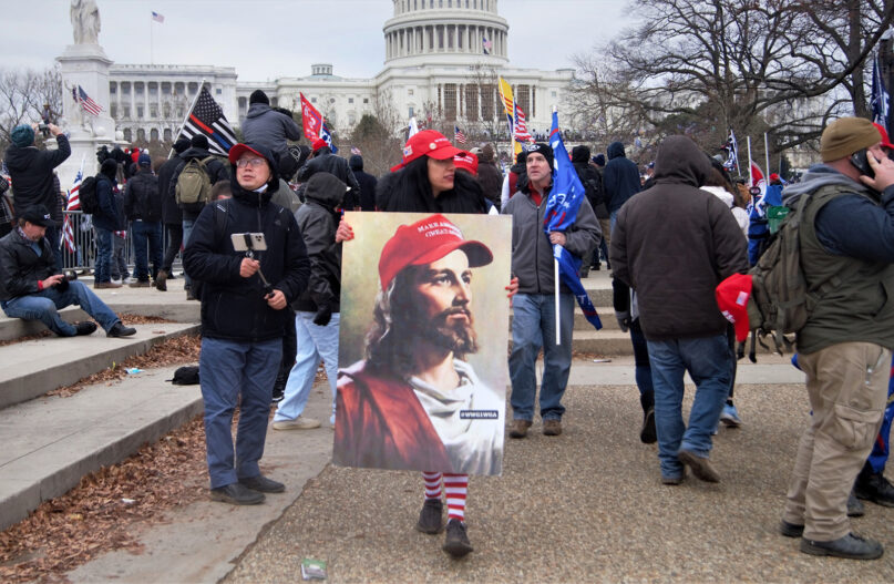 White #MAGA QAnon Jesus image carried during the Jan. 6, 2021, invasion of the Capitol. Photo by Tyler Merbler/Flickr/Creative Commons