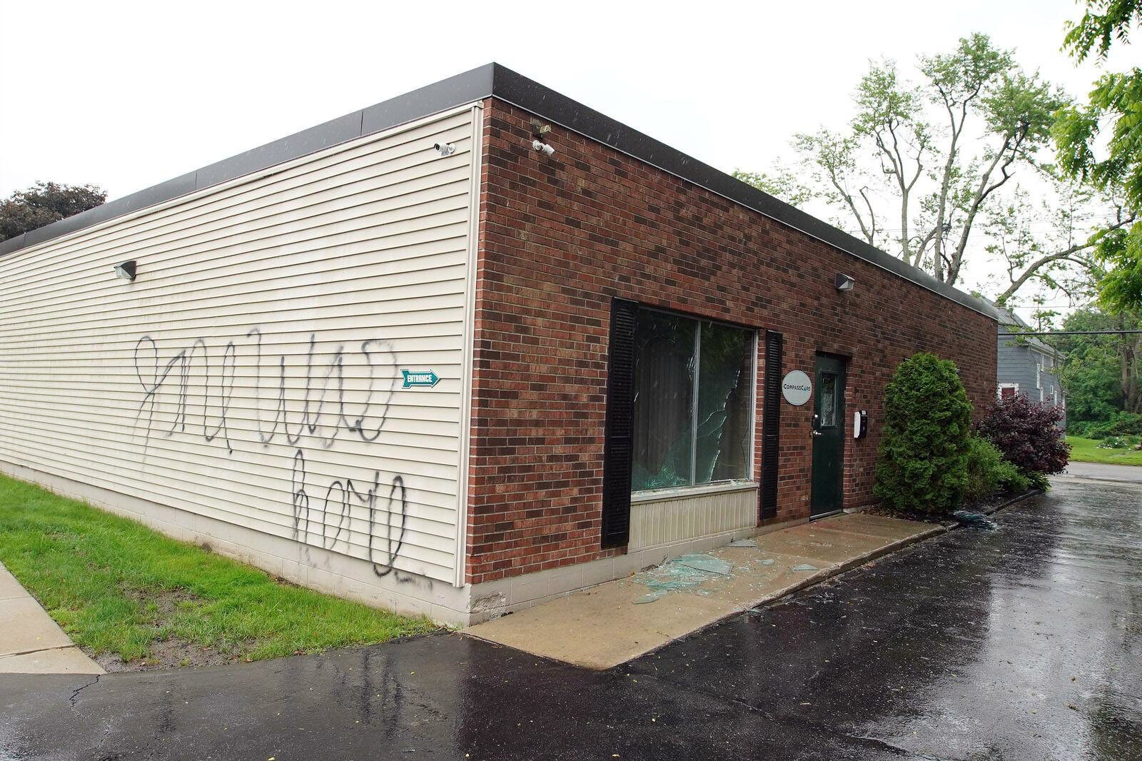 A wall is marked with graffiti reading "Jane was here" and broken glass covers the sidewalk after a suspected firebombing at CompassCare, a crisis pregnancy center in Eggertsville, near Buffalo, New York, on Tuesday, June 7, 2022. (Mark Mulville/Buffalo News via AP)