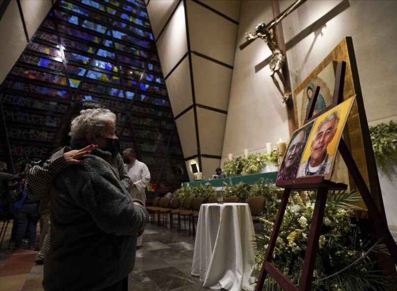 Faithful mourn in front of the photos of Jesuit priests Javier Campos Morales and Joaquin Cesar Mora Salazar during a Mass at a church in Mexico City, June 21, 2022. The two elderly priests were killed inside a church where a man pursued by gunmen apparently sought refuge in a remote mountainous area of northern Mexico, the religious order's Mexican branch announced Tuesday. (AP Photo/Fernando Llano)