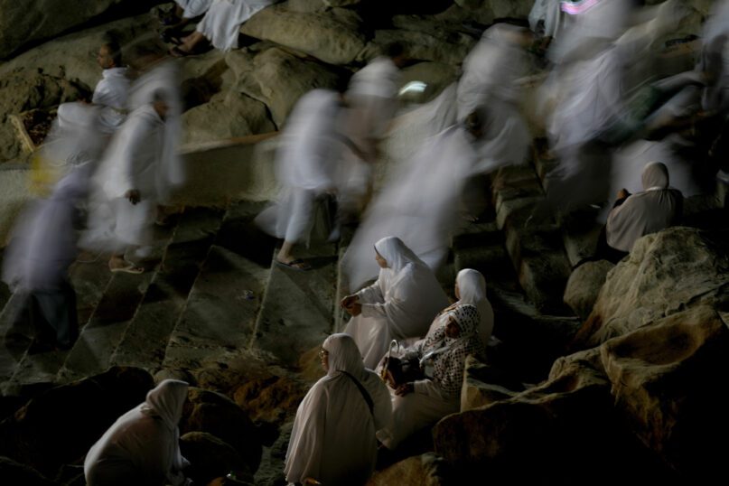 Muslim pilgrims pray on the rocky hill known as the Mountain of Mercy, on the Plain of Arafat, during the annual hajj pilgrimage, near the holy city of Mecca, Saudi Arabia, Friday, July 8, 2022. (AP Photo/Amr Nabil)