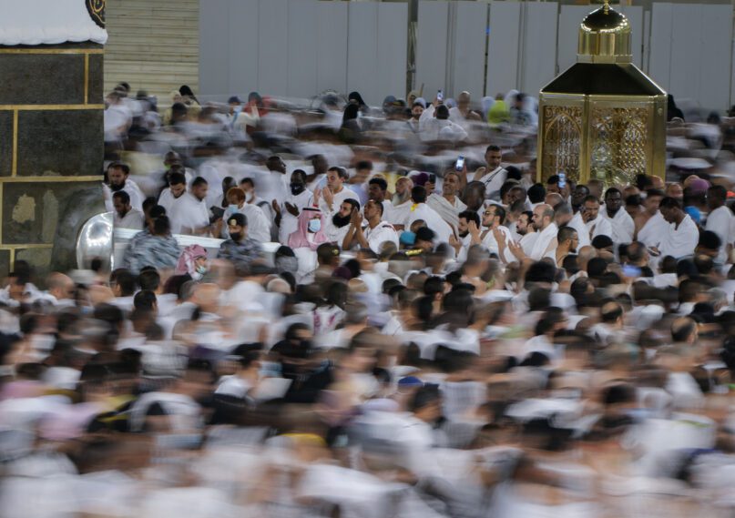 In this photo taken with low shutter speed, Muslim pilgrims pray as others circumambulate around the Kaaba, the cubic building at the Grand Mosque, in Mecca, Saudi Arabia, July 6, 2022. Muslim pilgrims are converging on Saudi Arabia's holy city of Mecca for the largest hajj since the coronavirus pandemic severely curtailed access to one of Islam's Five Pillars. (AP Photo/Amr Nabil)