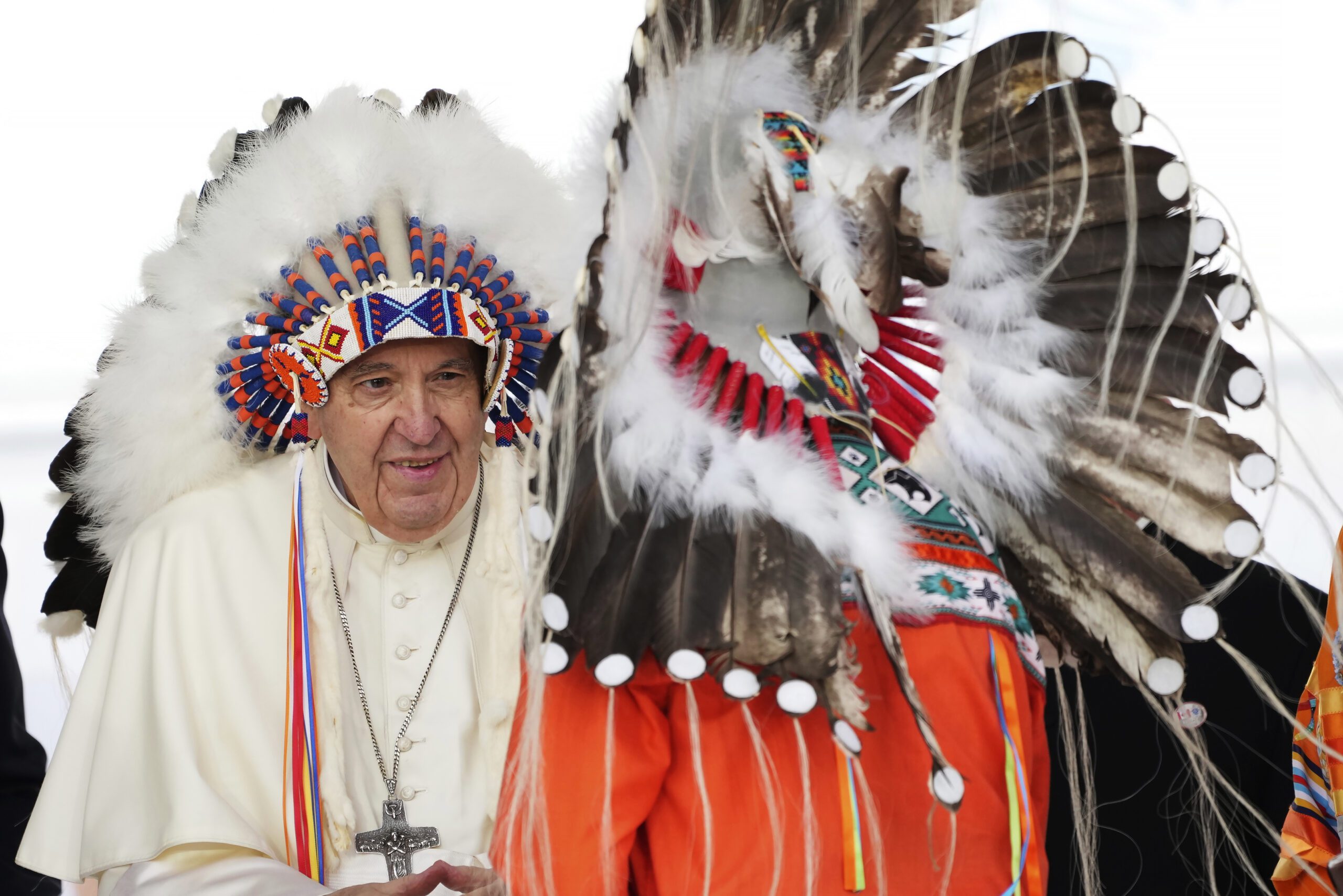 Pope Francis, left, wears a traditional headdress he was given after his apology to Indigenous people during a ceremony in Maskwacis, Alberta, as part of his papal visit across Canada, Monday, July 25, 2022. Pope Francis crisscrossed Canada this week delivering long overdue apologies to the country's Indigenous groups for the decades of abuses and cultural destruction they suffered at Catholic Church-run residential schools. (Nathan Denette/The Canadian Press via AP)