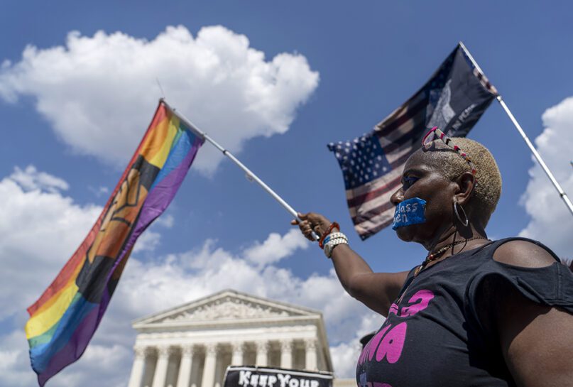 An abortion-rights protester waves a flag during a demonstration outside the Supreme Court in Washington, Saturday, June 25, 2022. The Supreme Court has ended constitutional protections for abortion that had been in place nearly 50 years, a decision by its conservative majority to overturn the court's landmark abortion cases. (AP Photo/Gemunu Amarasinghe)