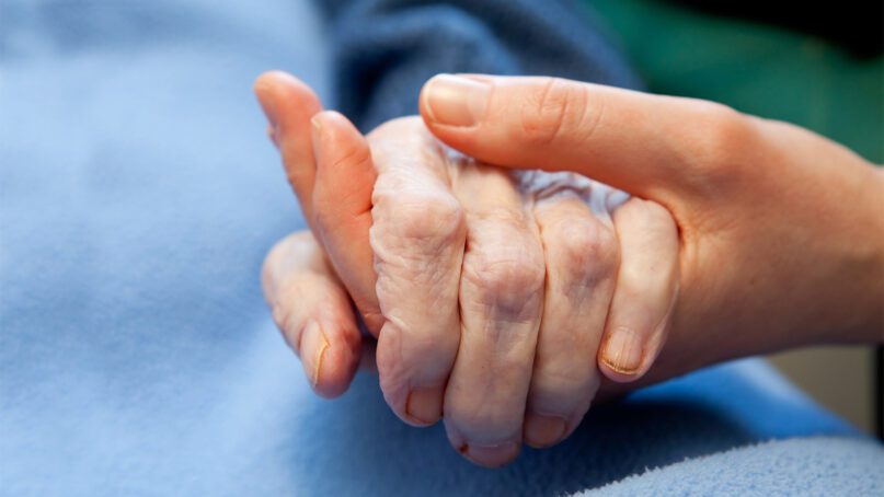 Holding hands in a hospital bed. Photo by Tyler Olson/Shutterstock
